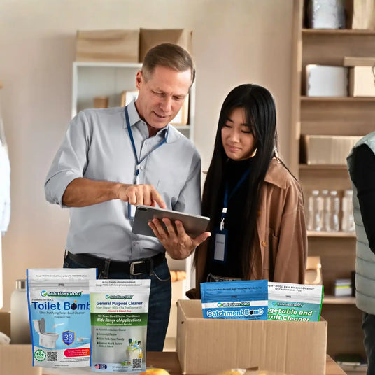 Two people looking at a tablet with cleaning products displayed in the foreground.