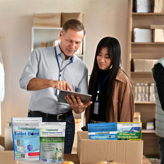 Two people looking at a tablet with cleaning products displayed in the foreground.