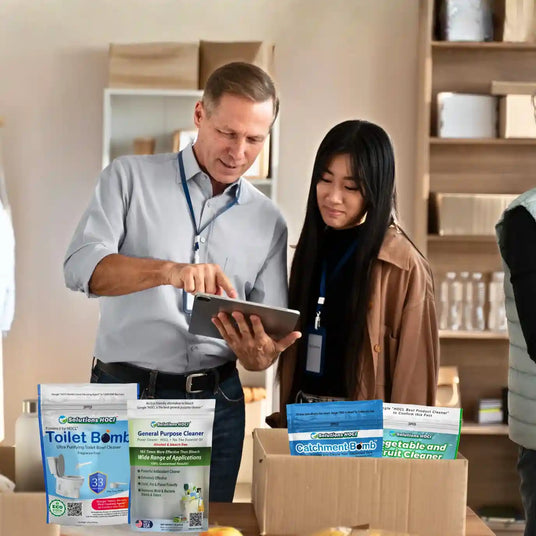 Two people in a room with cleaning products and a tablet.