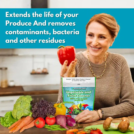 Woman holding a red pepper with a box of vegetable and fruit cleaner in a kitchen setting.